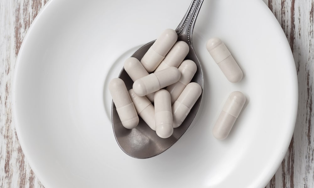 white vitamin capsules on a spoon